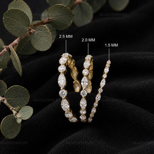 May include: Three gold eternity rings featuring alternating marquise and round cut clear stones. The rings are labeled with widths of 2.5 mm, 2.0 mm, and 1.5 mm, indicating the size of the stones or band width for each specific ring design.