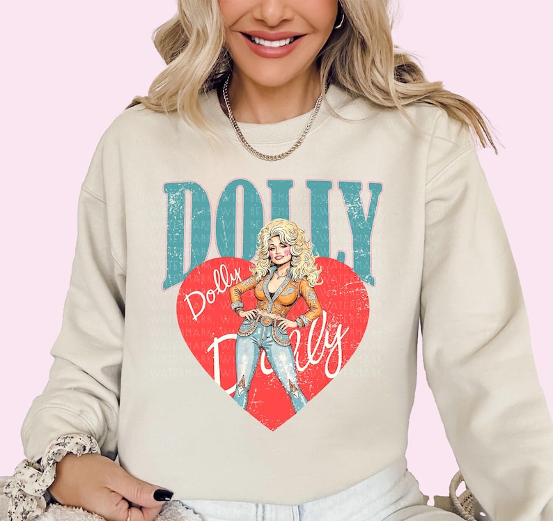 A woman wearing a white sweatshirt with a graphic design featuring a cartoon illustration of a blonde woman with curly hair and the text "Dolly Dolly" on it.