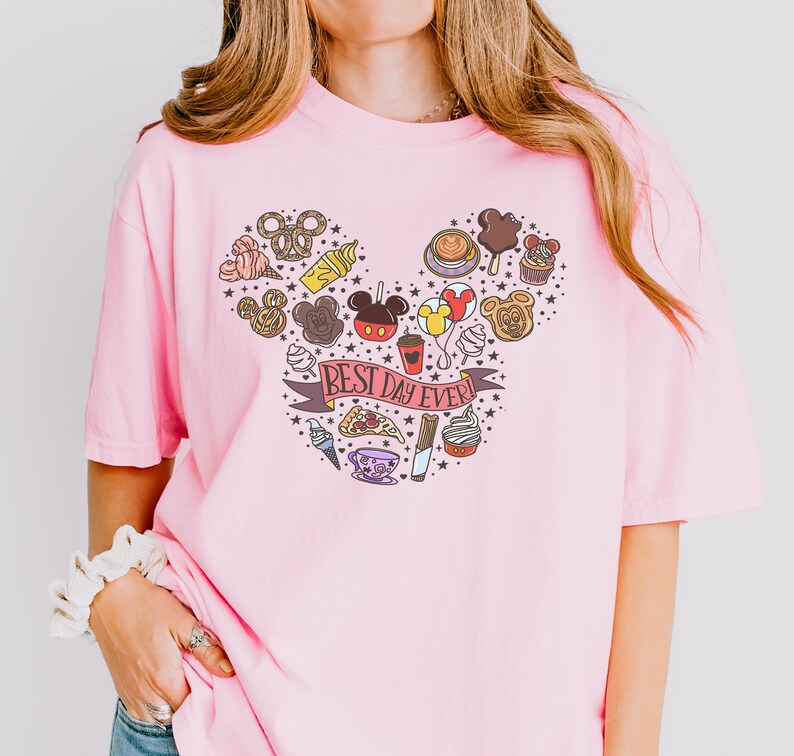 A woman wearing a pink t-shirt with a Mickey Mouse design and various Disney-themed items.