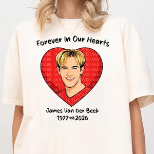 May include: Cream-colored t-shirt featuring a heart-shaped graphic with a portrait of James Van Der Beek. The heart is red with the words "Forever In Our Hearts" above and "James Van Der Beek 1977∞2026" below the image.