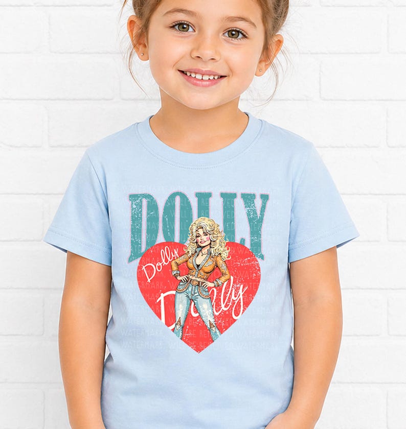 A young girl wearing a light blue t-shirt with a graphic of a woman and the text "Dolly Dolly" printed on it.