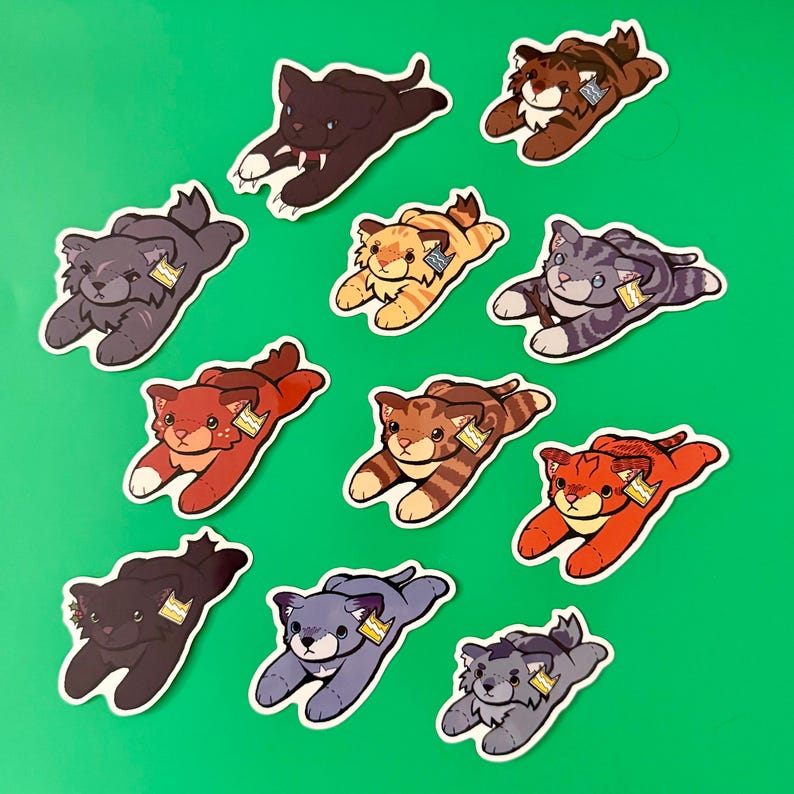May include: A collection of ten illustrated stickers featuring various cats in a prone, pouncing position. Each cat has a distinct color pattern, including brown, gray, orange, and black, and each wears a small, rectangular tag on its ear.