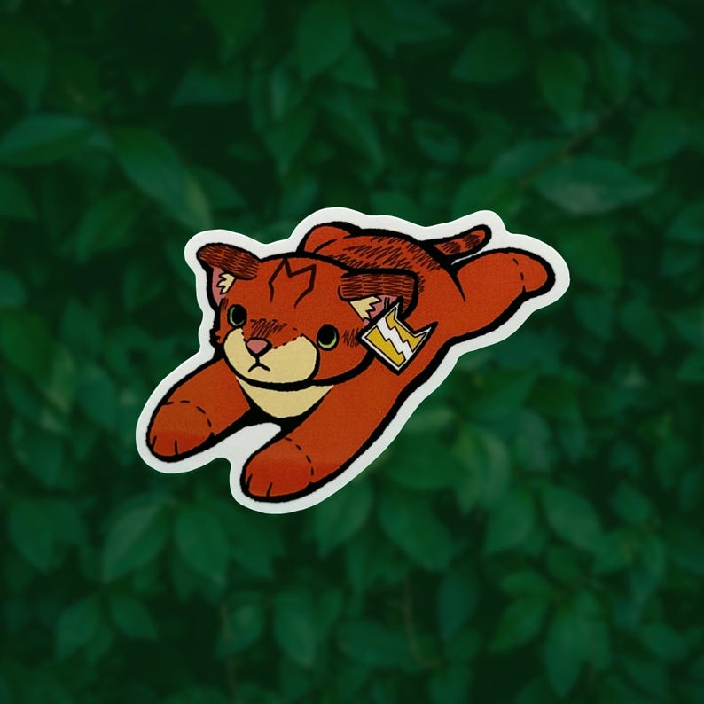 May include: A die-cut sticker featuring a stylized orange cat in a pouncing position. The cat has a cream-colored muzzle, dark brown ear markings, and a small tag attached to its ear displaying a yellow lightning bolt symbol on a white background.