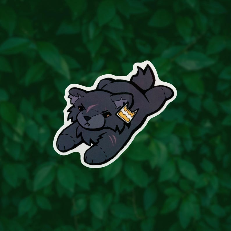 May include: A sticker featuring a dark gray, plush-style wolf character in a pouncing position. The wolf has stitched details, a small scar on its forehead, and a yellow tag with a white lightning bolt symbol attached to its ear with a white border.