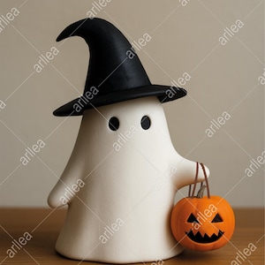 Może przedstawiać: Biała ceramiczna figurka ducha w czarnym kapeluszu czarownicy, trzymająca pomarańczową dynię. Duch ma dwa czarne oczy. Dekoracja na Halloween.