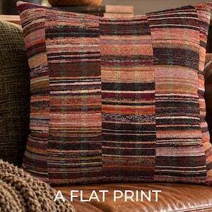May include: A square throw pillow featuring a multi-colored horizontal striped pattern in shades of brown, orange, red, and muted green. The fabric has a textured, woven appearance with a repeating block design. The text A FLAT PRINT is visible.