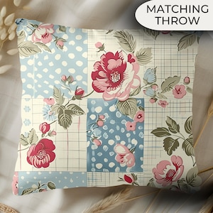 May include: Square throw pillow with a patchwork design. The pillow features floral patterns in shades of red, pink, and green on a cream background. Sections of the pillow have a light blue polka dot pattern. The text "MATCHING THROW" is in a white oval.