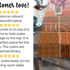 Op de afbeelding: Een rechthoekige tafelloper met een patchworkontwerp van diverse geometrische patronen in oranje, bruine en cr&egrave;metinten. De loper ligt op een houten tafel gedekt met blauwe kommen, wijnglazen en een vaas met roze lelies.