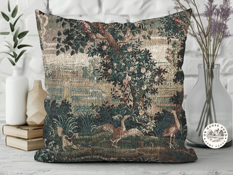 May include: Square cushion with a tapestry design depicting a landscape scene with trees, birds, and water. The colour scheme includes greens, browns, and beige, giving a vintage feel. The cushion is designed for decorative purposes.