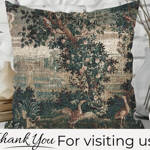 May include: Square cushion with a tapestry design depicting a landscape with trees, birds, and water features. The colour scheme includes green, brown, and beige tones. The cushion is made of woven fabric and is designed for home decor.