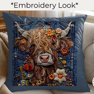 May include: A square throw pillow in dark blue featuring a central graphic of a Highland cow with long brown fur and horns, surrounded by colorful embroidered-style flowers, all set against a blue denim fabric background with pocket details.