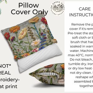 Pu&ograve; includere: Fodera per cuscino grigia con ricamo floreale nei colori arancione, giallo, rosso e blu. Il cuscino ha un dettaglio a righe e il testo "Pillow Cover Only". &Egrave; visibile anche il testo "*NOT* REAL Embroidery- A flat print".