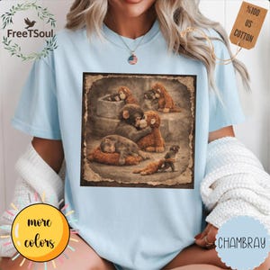 May include: Pale blue t-shirt with a sepia-toned image of monkeys. The image is framed with a distressed border. The shirt has the text "FreeTSoul" and a tag that says "100% US Cotton".