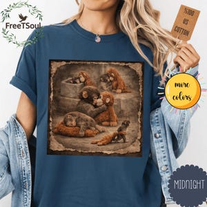 May include: A navy blue t-shirt with a sepia-toned image of plush monkey figures. The image shows the monkeys in different poses. The shirt has the text "FreeTSoul" and a tag that says "100% US Cotton".
