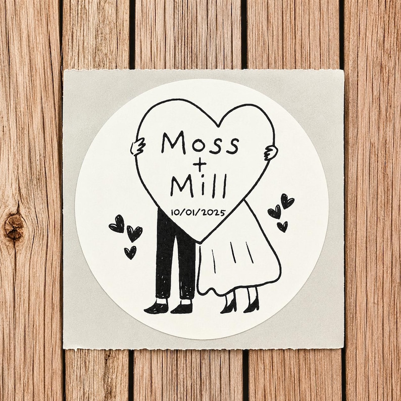 May include: A circular white sticker featuring a black line drawing of two figures holding a large heart. The heart contains the text Moss + Mill and the date 10/01/2025. Small black hearts are scattered around the figures on a light gray square.