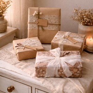 May include: Several wrapped gifts on a white table, decorated with dried flowers and lace. The gifts are wrapped in brown paper and patterned paper, tied with twine and ribbons, and adorned with tags. A candle and vases are in the background.