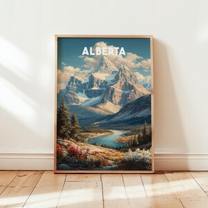 Può includere: Una stampa artistica incorniciata con un paesaggio panoramico dell'Alberta, in Canada. L'opera presenta montagne innevate, un fiume tortuoso e una vegetazione lussureggiante. La parola "ALBERTA" è visualizzata in bianco nella parte superiore della stampa.