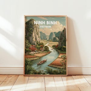 May include: A framed travel poster of Ninh Binh, Vietnam. The artwork shows a river scene with limestone mountains, rice paddies, and a traditional boat. The poster has the text "NINH BINH VIETNAM" in white.