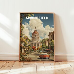 Puede incluir: Una impresión artística enmarcada que presenta una escena callejera en Springfield. La obra de arte representa un gran edificio con una cúpula roja, un coche clásico y la palabra "SPRINGFIELD" en la parte superior. La escena está representada en colores cálidos, con árboles y edificios.