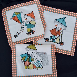 May include: Three white handkerchiefs with colorful illustrations of children. One child is flying a kite, another is riding a scooter, and the third is with a girl. Each handkerchief has an orange and teal checkered border.