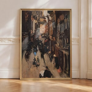 Puede incluir: Una pintura enmarcada de estilo antiguo representa una escena callejera bulliciosa. La obra de arte presenta tonos apagados de marrón, negro y beige, con toques de azul y rosa. La pintura está enmarcada en un marco dorado, añadiendo un toque de elegancia.