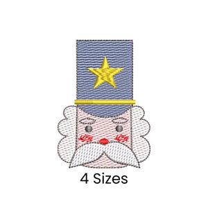 Puede incluir: Diseño bordado de la cara de un soldado de juguete, con un sombrero azul con una estrella dorada, un bigote blanco y una boca roja. El texto "4 Sizes" se muestra debajo del diseño.