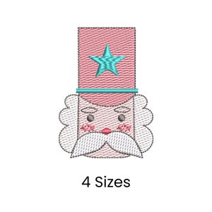 Puede incluir: Diseño bordado de la cara de un soldado de juguete con un sombrero rosa y una estrella turquesa. El soldado tiene un bigote blanco y una cara rosada. El texto "4 Sizes" está debajo.