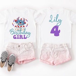 Puede incluir: Dos camisetas blancas con shorts rosas a juego y zapatos a cuadros blancos y negros. Una camiseta presenta un personaje de dibujos animados y las palabras "Birthday Girl". La otra camiseta tiene el nombre "Lily" y el n&uacute;mero "4".
