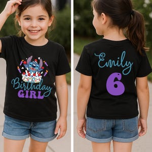 Puede incluir: Camiseta negra con un dise&ntilde;o de personaje de dibujos animados y las palabras "Birthday Girl". La parte trasera de la camiseta tiene el nombre "Emily" y el n&uacute;mero "6". La ni&ntilde;a lleva pantalones cortos vaqueros.