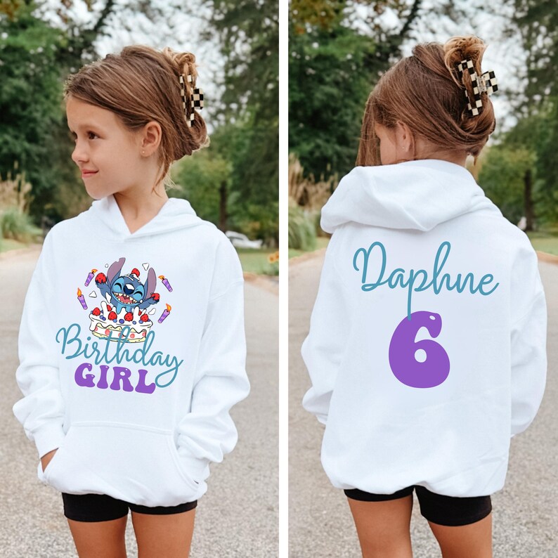 Puede incluir: Sudadera con capucha blanca con un personaje de dibujos animados, una tarta de cumplea&ntilde;os y las palabras "Birthday Girl". La parte trasera de la sudadera tiene el nombre "Daphne" y el n&uacute;mero "6" en morado.