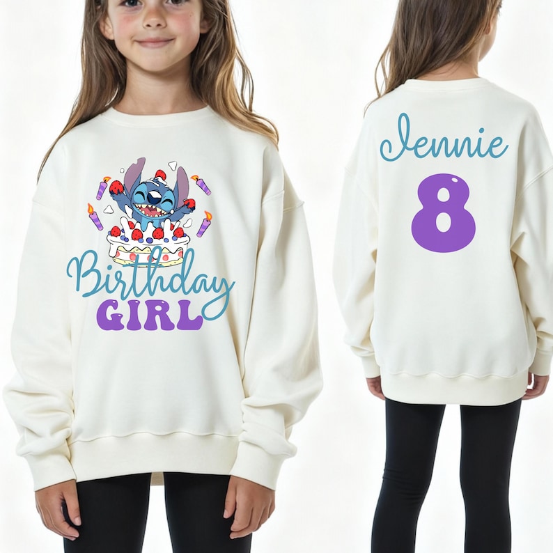 Puede incluir: Sudadera de color crema con un personaje de dibujos animados y las palabras "Birthday Girl" en azul y morado. La parte trasera de la sudadera tiene el nombre "Jennie" en escritura azul y el n&uacute;mero "8" en morado.