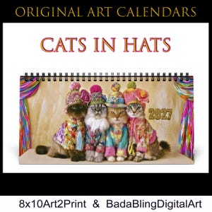 May include: A 2027 wall calendar titled "ORIGINAL ART CALENDARS" and "CATS IN HATS" featuring four cats wearing colorful knit hats and patterned jackets. The cats are positioned in front of a beige backdrop with rainbow-colored curtains on the sides.