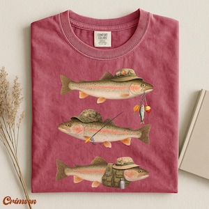 Crimson Comfort Colors® shirt folded flat, design shows three trout in detailed fisherman outfits with rod, lures, and vest.