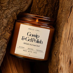May include: A brown glass jar with a dark brown lid. The jar has a white label with the text "Gossip & Gel Polish" and "World's best nail tech". The label also includes the words "Glitter, Secrets, Patience, Made with Love".
