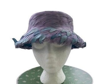 May include: A purple and blue hat with feathers on a green and white box.