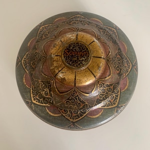 May include: A handmade wooden sign with the text "Welcome" in a whimsical font. The sign is painted white with a distressed finish, and features a decorative floral design in shades of pink and green. It measures approximately 12 inches wide.