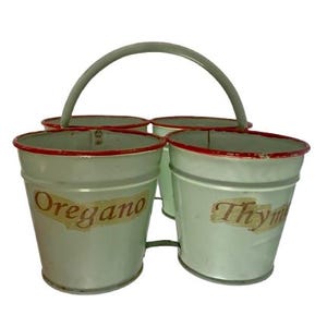 May include: A four-pot herb planter in light green metal, featuring red rims and a grey handle. The pots are labelled "Oregano" and "Thyme", ideal for growing herbs in a kitchen or garden setting.