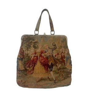 Puede incluir: Bolso de mano vintage de tapiz con una escena romántica con figuras con trajes de época. El bolso tiene una forma estructurada, un asa superior y un cierre de broche. El diseño del tapiz incluye tonos de rojo, dorado y verde.