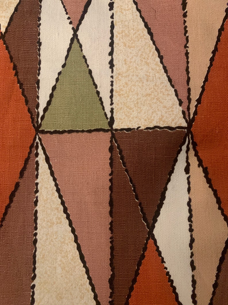 Peut inclure: Tissu &agrave; motif g&eacute;om&eacute;trique avec des triangles bruns, beiges, roses et oranges. Le tissu a une surface textur&eacute;e et un contour noir autour de chaque triangle.