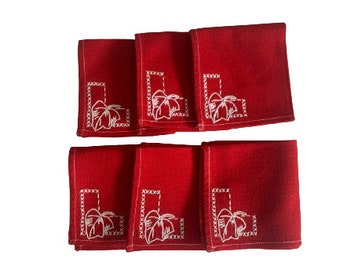 May include: Set of six red linen napkins with white embroidered palm tree designs.