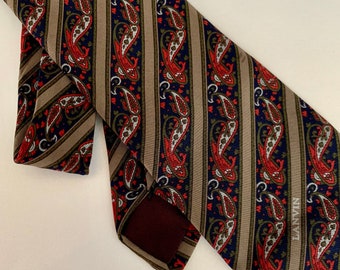 May include: A brown, blue, red, and green paisley patterned silk tie with a burgundy lining. The tie has the word "LANVIN" printed on the bottom right corner.