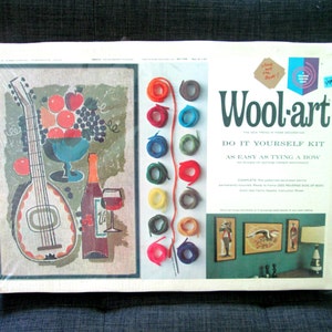 Peut inclure: Kit de bricolage Wool-art, un kit d'artisanat vintage illustrant une guitare, des fruits et une bouteille de vin colorés. Le kit comprend du fil de laine pré-coupé en différentes couleurs, une aiguille et des instructions.