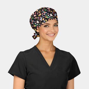 May include: A black surgical scrub cap with a colorful pattern of toys, ornaments, and stars. The cap is tied at the back. The person is wearing a black V-neck scrub top.