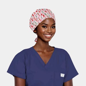 May include: A pink scrub cap with a Christmas stocking pattern. The cap features red, green, and white stockings, candy canes, and other festive designs. The cap is tied in the back and worn with a blue scrub top.