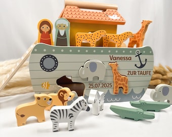 Könnte beinhalten: Ein hölzernes Arche Noah Steckspiel mit hellgrünem Rumpf, Bullauge, Anker und dem Text Vanessa, ZUR TAUFE, 25.07.2025. Es enthält verschiedene Tierfiguren wie ein Zebra, einen Löwen, einen Elefanten, eine Giraffe und einen Geparden.