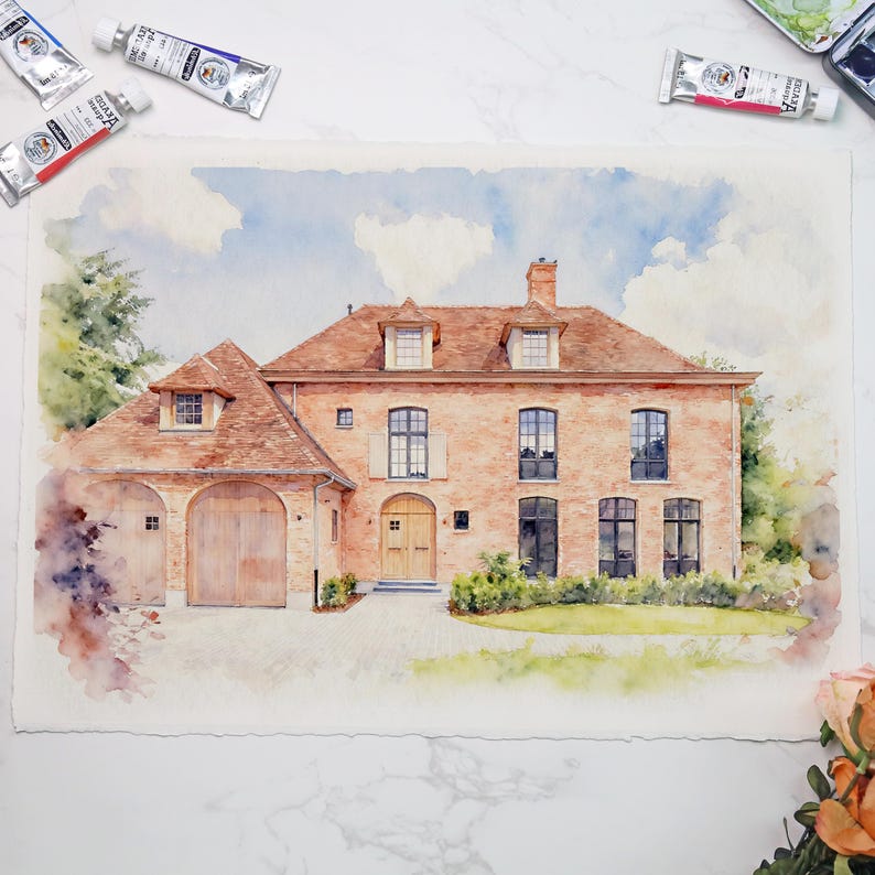 May include: Watercolor painting of a two-story brick house with a red tile roof, dormer windows, and a wooden garage door. The artwork features a driveway, landscaping, and a cloudy sky. Paint tubes are visible in the background.