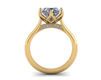 May include: A gold engagement ring with a large, clear gemstone. The ring features a unique floral-inspired setting and small accent stones. The band is smooth and polished, creating a classic and elegant look.