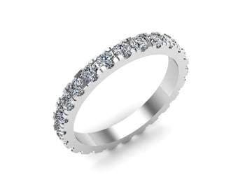 May include: A silver band ring with a continuous row of small, clear gemstones. The ring is set against a white background, showcasing its polished metal and sparkling stones. The ring is a classic design.