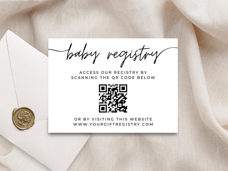 May include: A white baby registry card with black text and a QR code. The card reads "baby registry" in cursive, with instructions to scan the QR code or visit a website. An envelope with a gold seal is in the background.