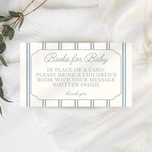 May include: A rectangular card with the text "Books for Baby" in a decorative font. The card has a cream background with blue vertical stripes and a blue border. The text encourages guests to bring a children's book instead of a card.